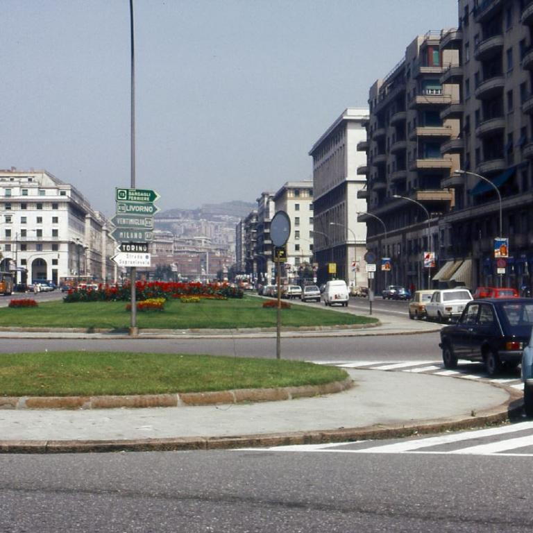 Urbaner Blick auf einen belebten Kreisverkehr, umgeben von hohen, mehrstöckigen Gebäuden.