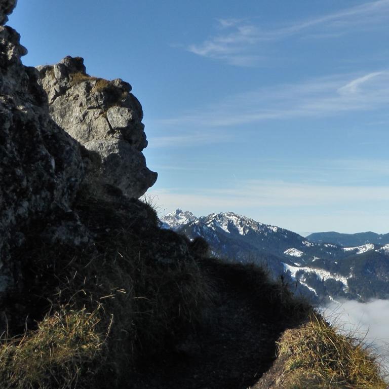 Steilküste mit Felsenabhang, die über eine Nebelschicht hinabblickt.