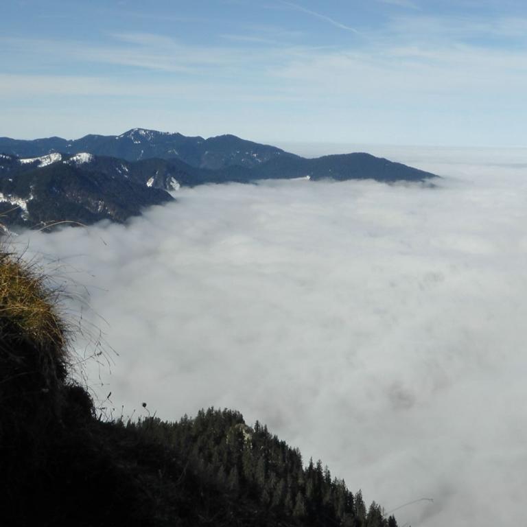 Panoramablick von einem Bergvorsprung über eine Wolkendecke.